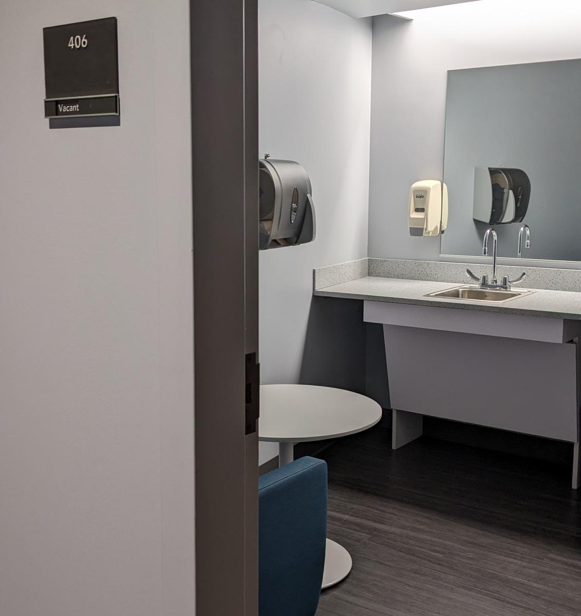 Image of a lactation room at Lehigh that includes a comfortable chair, table and sink.